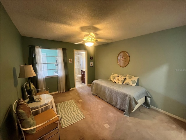 bedroom featuring carpet floors, ensuite bath, a textured ceiling, baseboards, and a ceiling fan