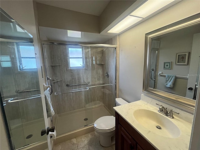 bathroom with toilet, a stall shower, and vanity