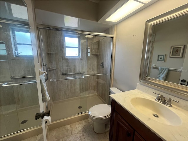 bathroom featuring toilet, a shower stall, and vanity
