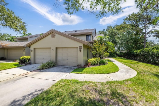 3066 Landmark Blvd Unit 1305, Palm Harbor, FL 34684 - view of front facade featuring a garage, a front lawn, stucco siding, and driveway