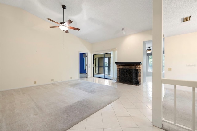 3066 Landmark Blvd Unit 1305, Palm Harbor, FL 34684 - unfurnished living room featuring a ceiling fan, a fireplace, light tile patterned floors, a textured ceiling, and high vaulted ceiling