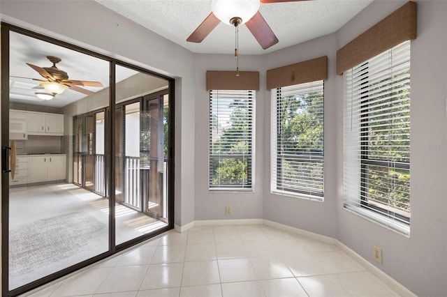 3066 Landmark Blvd Unit 1305, Palm Harbor, FL 34684 - empty room with ceiling fan, baseboards, light tile patterned flooring, and a textured ceiling