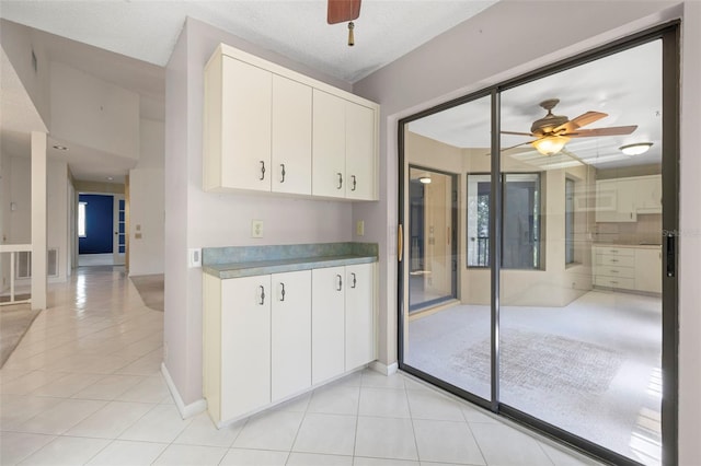 3066 Landmark Blvd Unit 1305, Palm Harbor, FL 34684 - kitchen with light tile patterned flooring, ceiling fan, white cabinets, and baseboards