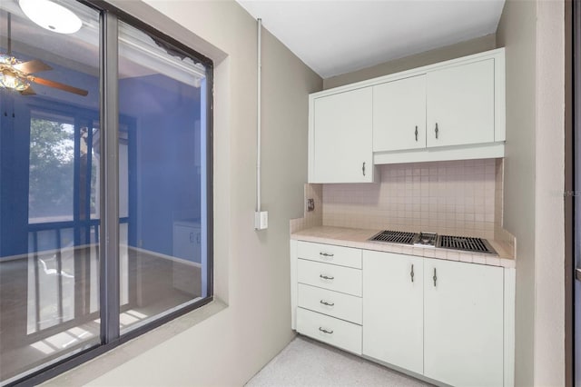 3066 Landmark Blvd Unit 1305, Palm Harbor, FL 34684 - kitchen with backsplash, white cabinetry, ceiling fan, tile counters, and stainless steel gas cooktop