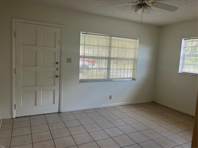 entryway with baseboards, light tile patterned flooring, ceiling fan, and a textured ceiling