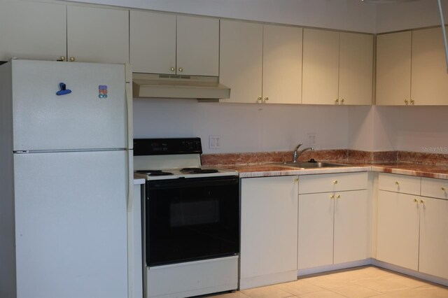 11447 Park Blvd Unit 301, Seminole, FL 33772 - kitchen featuring under cabinet range hood, freestanding refrigerator, electric range, a sink, and light tile patterned floors