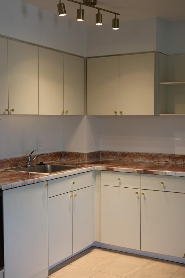 11447 Park Blvd Unit 301, Seminole, FL 33772 - kitchen with a sink, light tile patterned floors, and white cabinetry