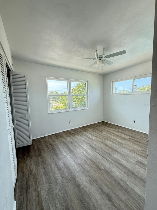 11447 Park Blvd Unit 301, Seminole, FL 33772 - unfurnished bedroom with dark wood-type flooring, multiple windows, baseboards, and a closet