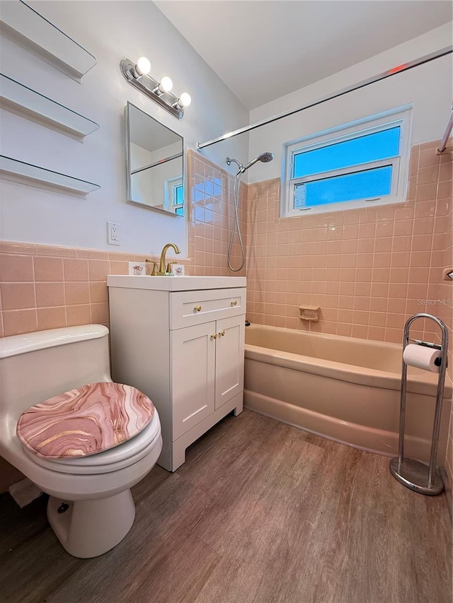 11447 Park Blvd Unit 301, Seminole, FL 33772 - bathroom featuring tile walls, wood finished floors, bathing tub / shower combination, vanity, and toilet