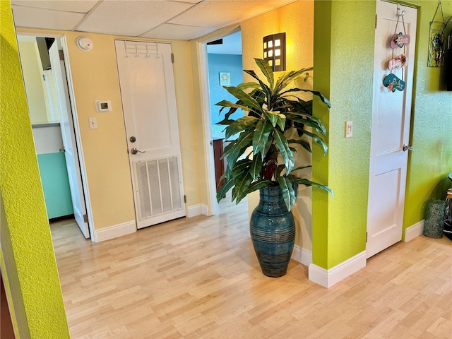 entrance foyer with baseboards, visible vents, a textured wall, and wood finished floors
