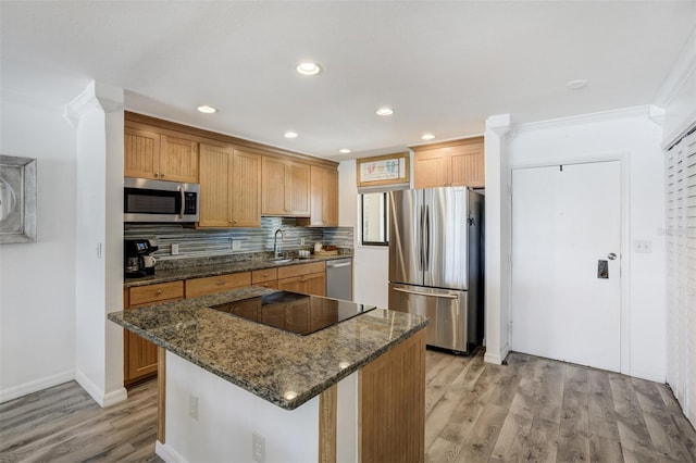 kitchen with stainless steel appliances, a sink, light wood-type flooring, ornamental molding, and decorative backsplash