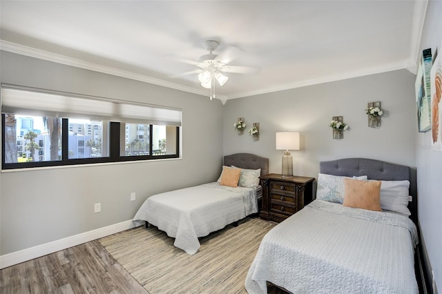 bedroom with crown molding, baseboards, wood finished floors, and a ceiling fan
