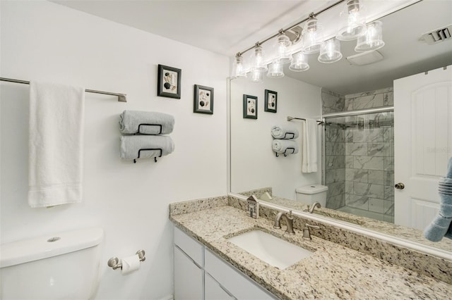 bathroom featuring toilet, a stall shower, and vanity