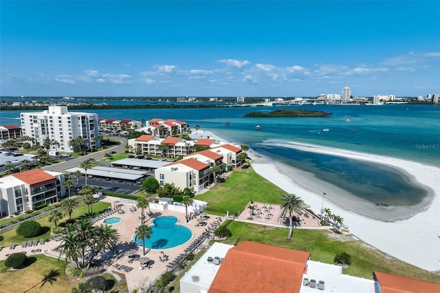 aerial view of a pool, a nearby body of water, and apartment complex