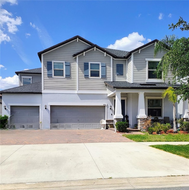 11704 Navajo Sandstone St, Riverview, FL 33579 - view of front of house featuring decorative driveway, an attached garage, covered porch, stucco siding, and a shingled roof