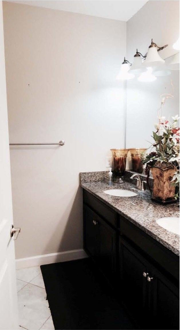11704 Navajo Sandstone St, Riverview, FL 33579 - bathroom with double vanity, tile patterned floors, and baseboards