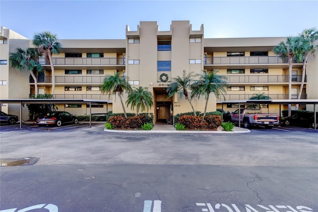 view of apartment building / complex with covered parking