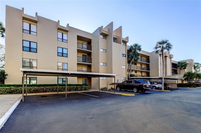 view of apartment building / complex with covered parking