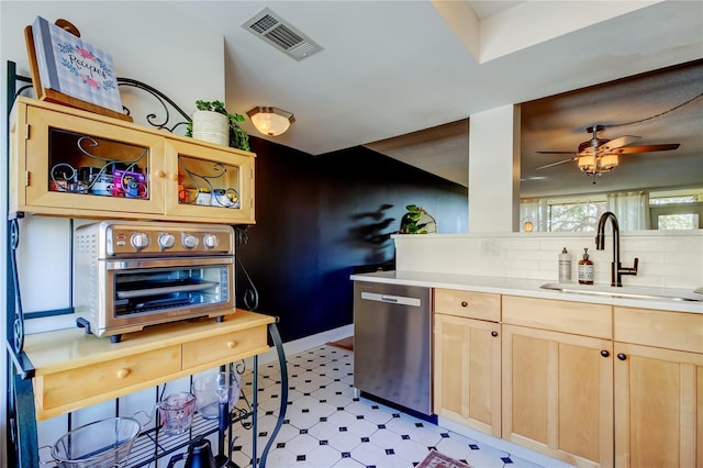 kitchen featuring a sink, light brown cabinetry, dishwasher, light floors, and light countertops