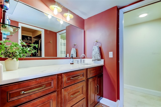 full bath featuring vanity and baseboards