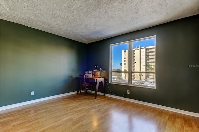 office space with wood finished floors, baseboards, and a textured ceiling