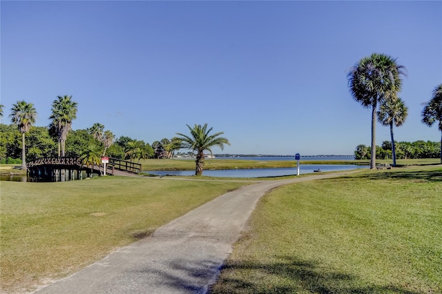 view of community with a yard and a water view