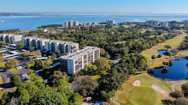 drone / aerial view of a large body of water, apartment complex / building, and a golf club
