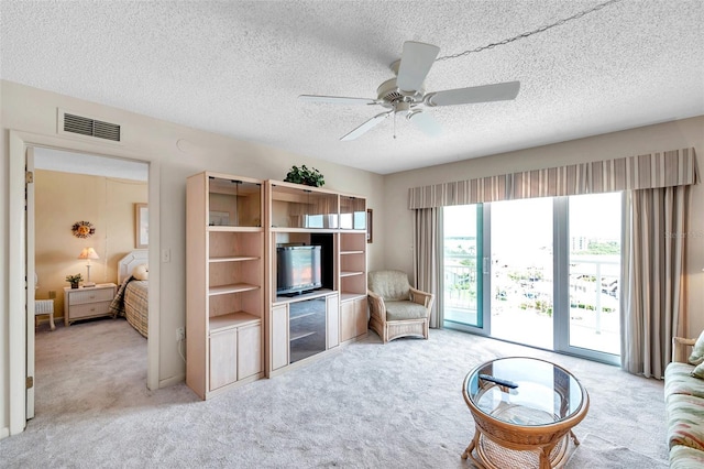 4900 Brittany Dr S Unit 805, Saint Petersburg, FL 33715 - living room featuring light colored carpet, a textured ceiling, and a ceiling fan