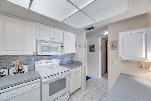 4900 Brittany Dr S Unit 805, Saint Petersburg, FL 33715 - kitchen with white appliances, white cabinetry, light tile patterned floors, tasteful backsplash, and light countertops