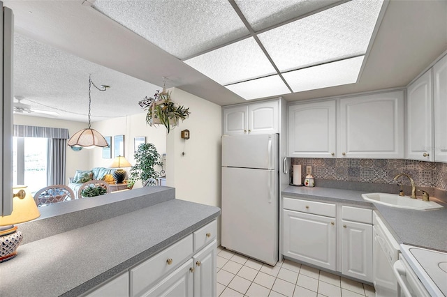 4900 Brittany Dr S Unit 805, Saint Petersburg, FL 33715 - kitchen featuring white appliances, a sink, light tile patterned floors, white cabinets, and pendant lighting