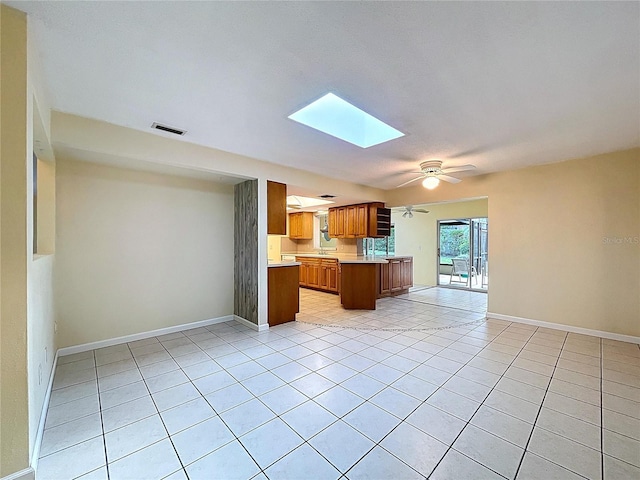 232 Pinecrest Dr, Palm Harbor, FL 34683 - kitchen with open floor plan, light tile patterned flooring, a skylight, and light countertops
