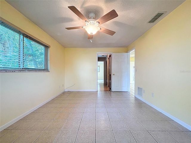 232 Pinecrest Dr, Palm Harbor, FL 34683 - empty room with a textured ceiling, light tile patterned floors, and ceiling fan