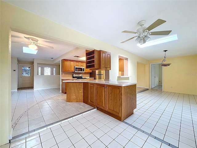 232 Pinecrest Dr, Palm Harbor, FL 34683 - kitchen with stainless steel appliances, a ceiling fan, a skylight, and light tile patterned floors