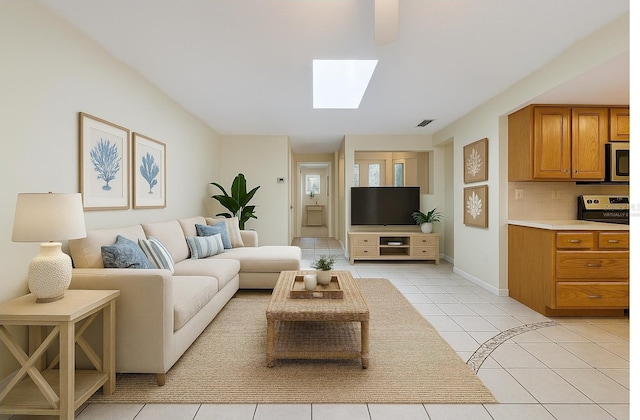 232 Pinecrest Dr, Palm Harbor, FL 34683 - living room with light tile patterned flooring and a skylight