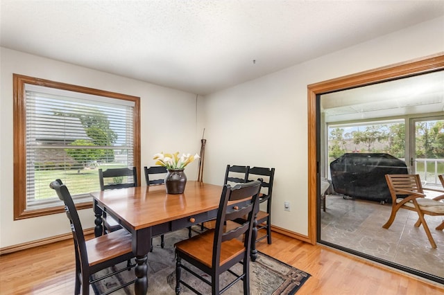 dining area featuring light wood finished floors and baseboards