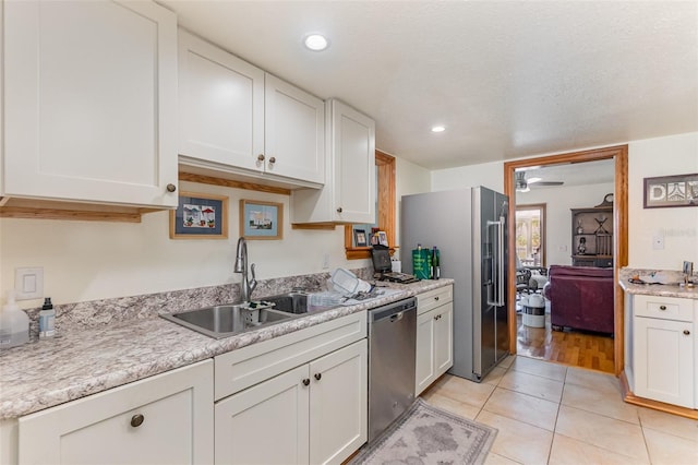 kitchen with a sink, white cabinetry, light countertops, and appliances with stainless steel finishes