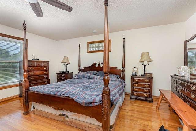 bedroom featuring ceiling fan, a textured ceiling, baseboards, and light wood-type flooring