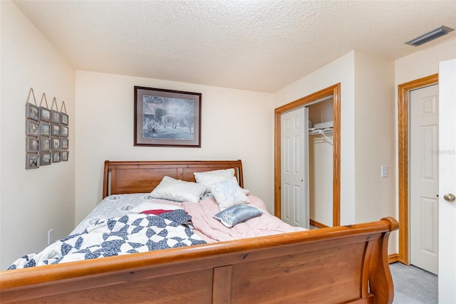 bedroom featuring a closet, visible vents, and a textured ceiling