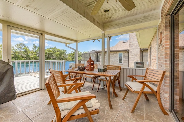 sunroom / solarium with a water view, ceiling fan, and plenty of natural light