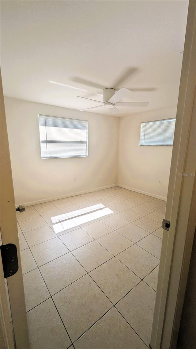 5122 Dove Dr, New Port Richey, FL 34652 - spare room featuring light tile patterned floors, baseboards, and ceiling fan