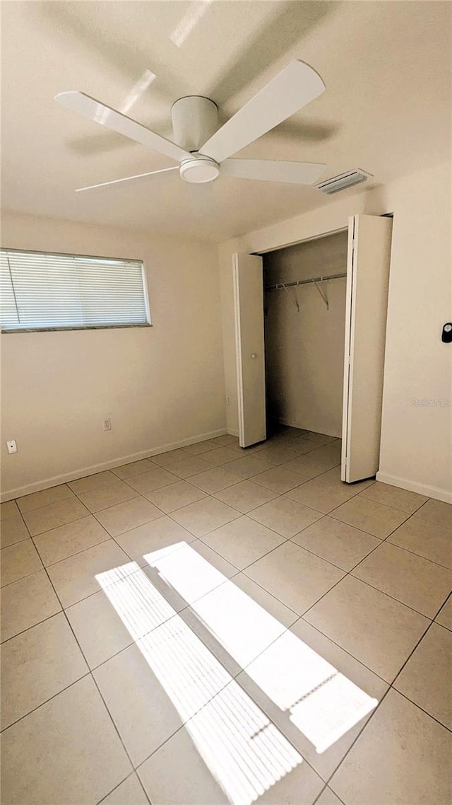 5122 Dove Dr, New Port Richey, FL 34652 - unfurnished bedroom featuring ceiling fan, a closet, light tile patterned floors, and visible vents