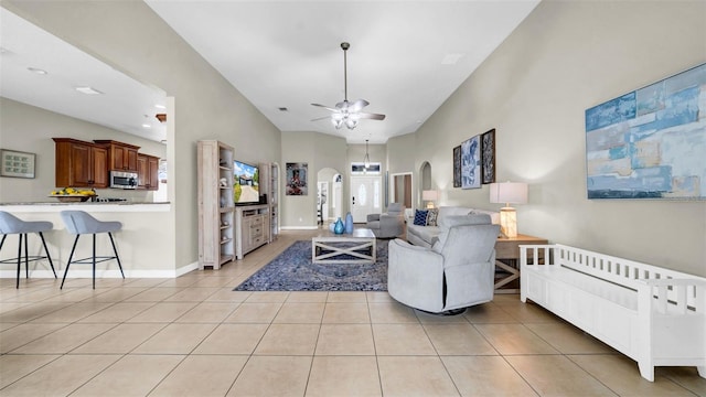 living room featuring arched walkways, ceiling fan, and light tile patterned floors