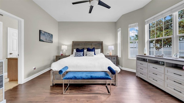 bedroom with dark wood-style floors, baseboards, multiple windows, lofted ceiling, and ceiling fan