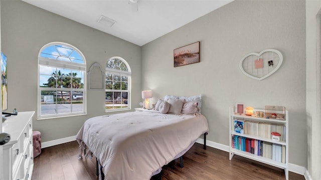 bedroom with wood finished floors, baseboards, and lofted ceiling