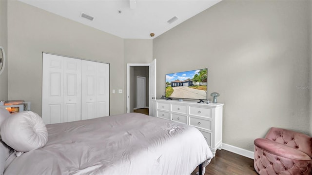 bedroom with dark wood-style floors, baseboards, and a closet