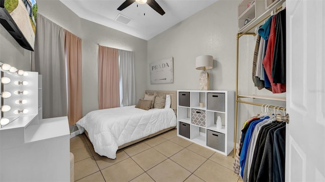 bedroom featuring lofted ceiling, light tile patterned floors, and a ceiling fan