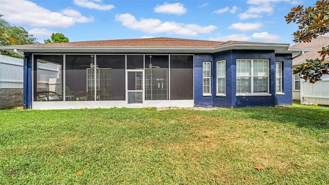 rear view of house with a yard and a sunroom