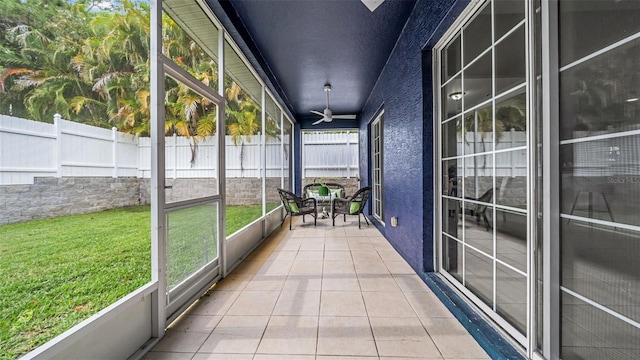 unfurnished sunroom featuring ceiling fan