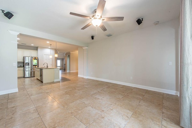 unfurnished living room with ceiling fan, a sink, baseboards, recessed lighting, and light tile patterned floors
