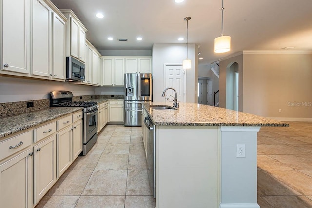 kitchen with appliances with stainless steel finishes, arched walkways, a sink, crown molding, and an island with sink